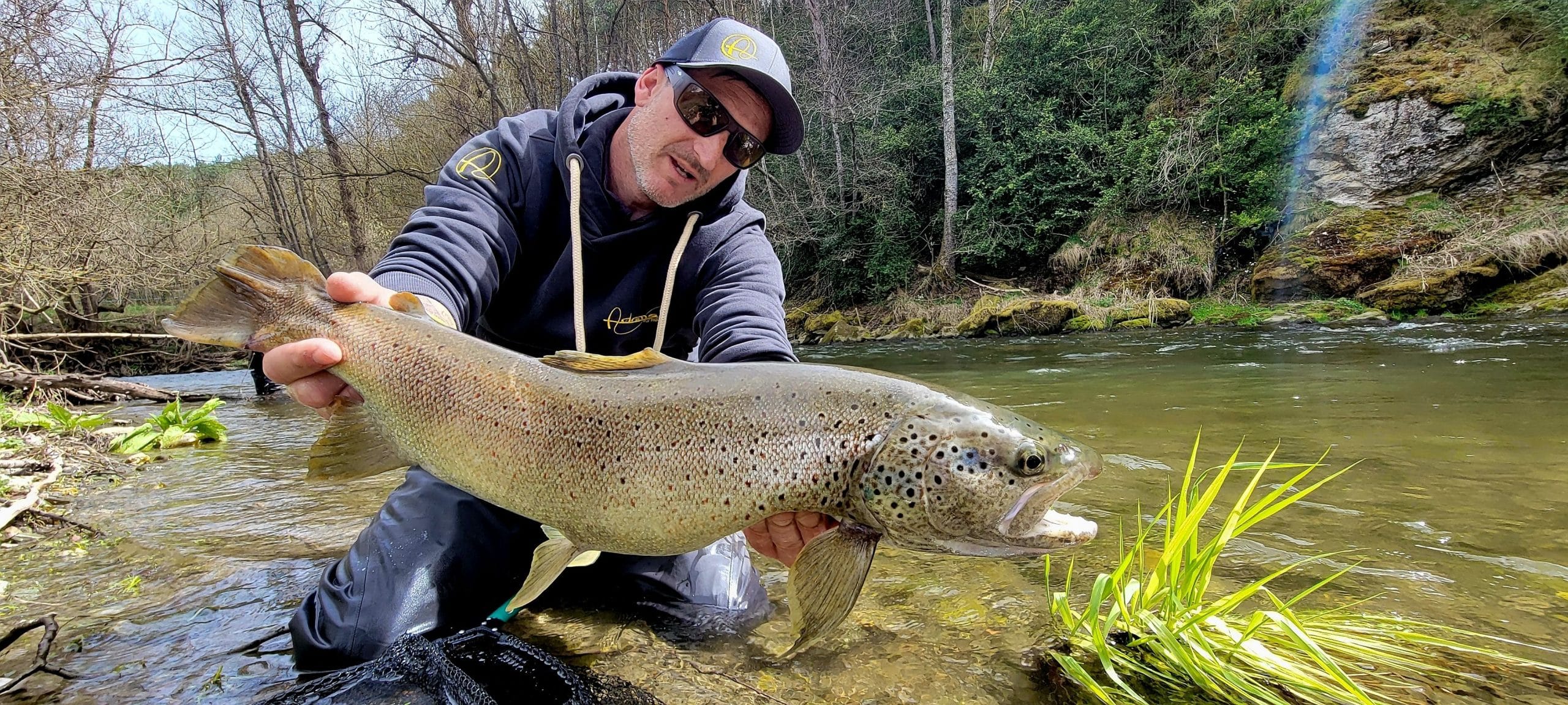 a man holding a fish in the water